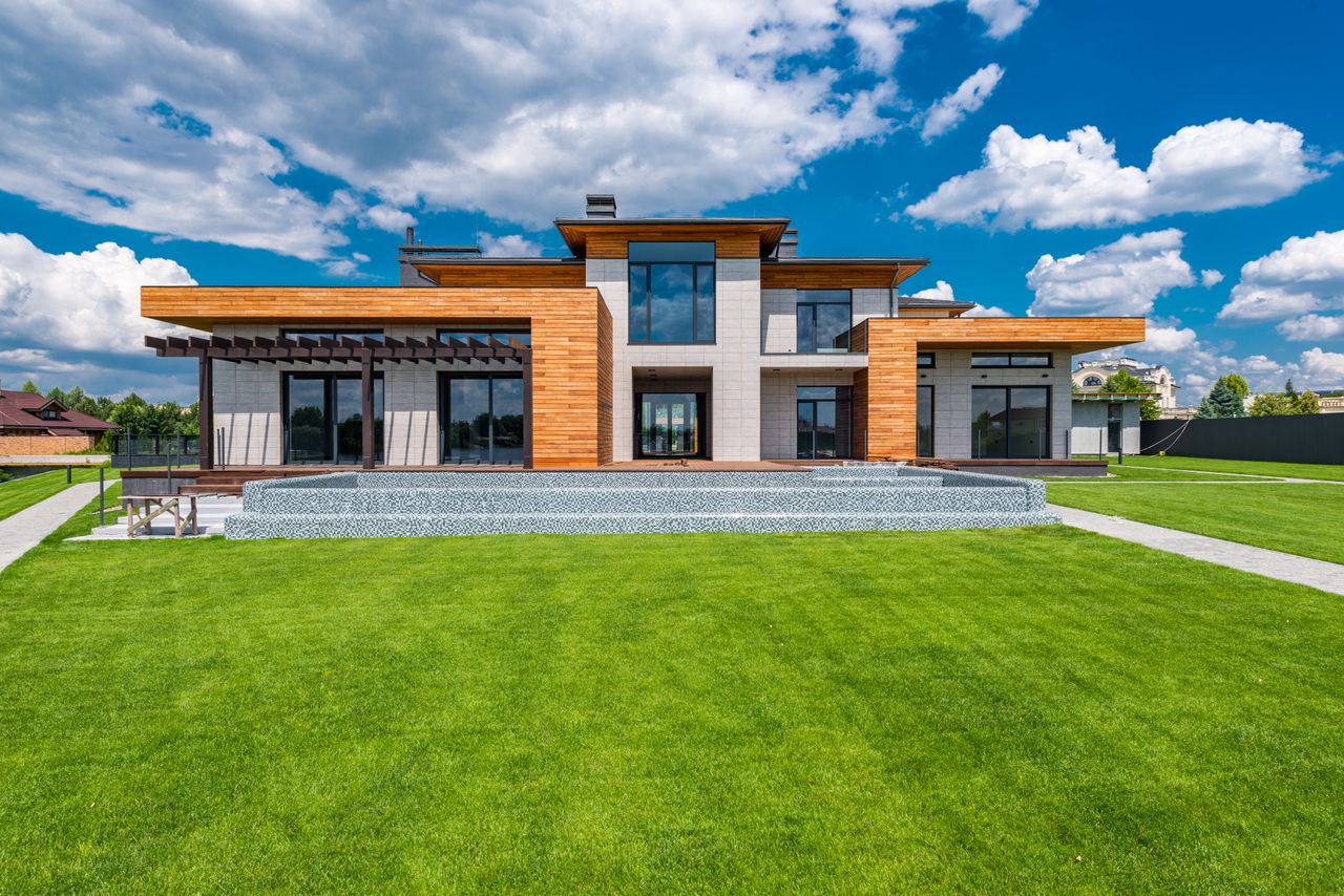 Exterior of contemporary building with green grass in yard in daytime under blue sky
